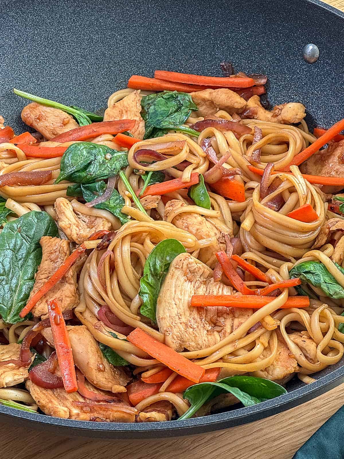 Closeup of chicken noodle stir fry with tender chicken and colorful vegetables