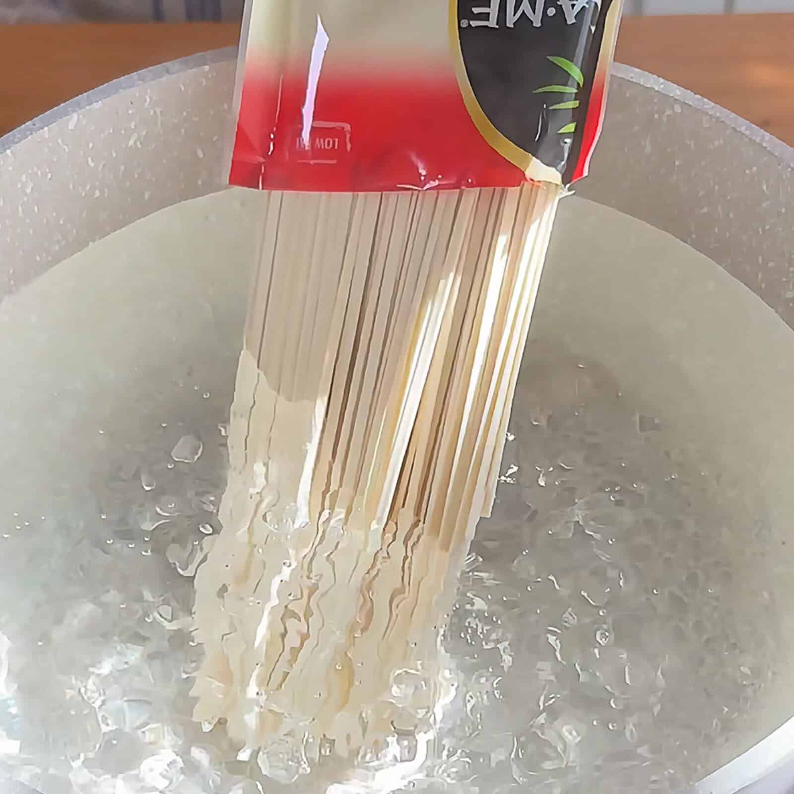 Udon noodles boiling in large pot of water