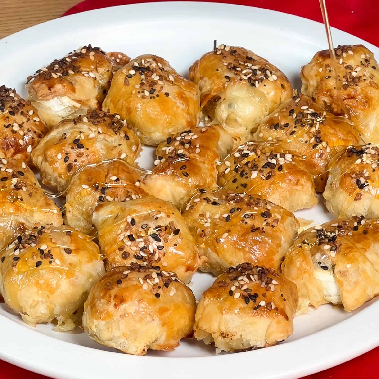 Drizzling honey over puff pastry bites filled with brie and fig