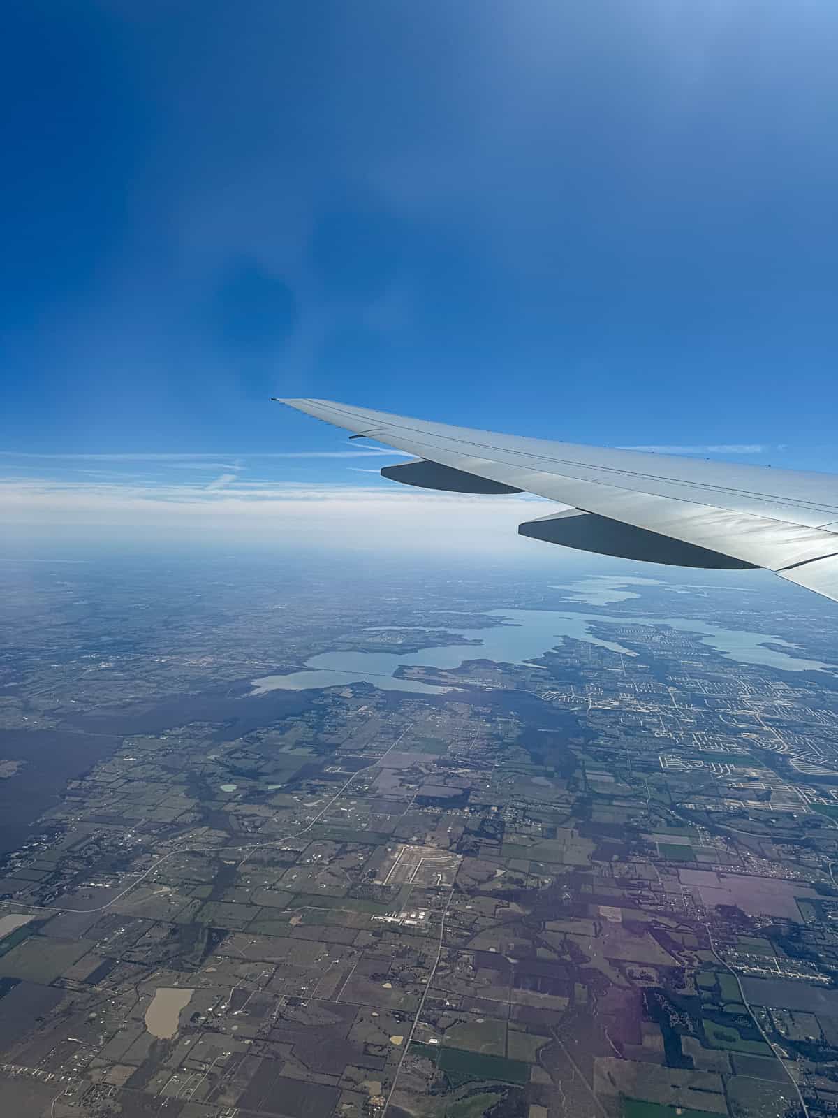 American Airlines plane flying above clouds with aerial view