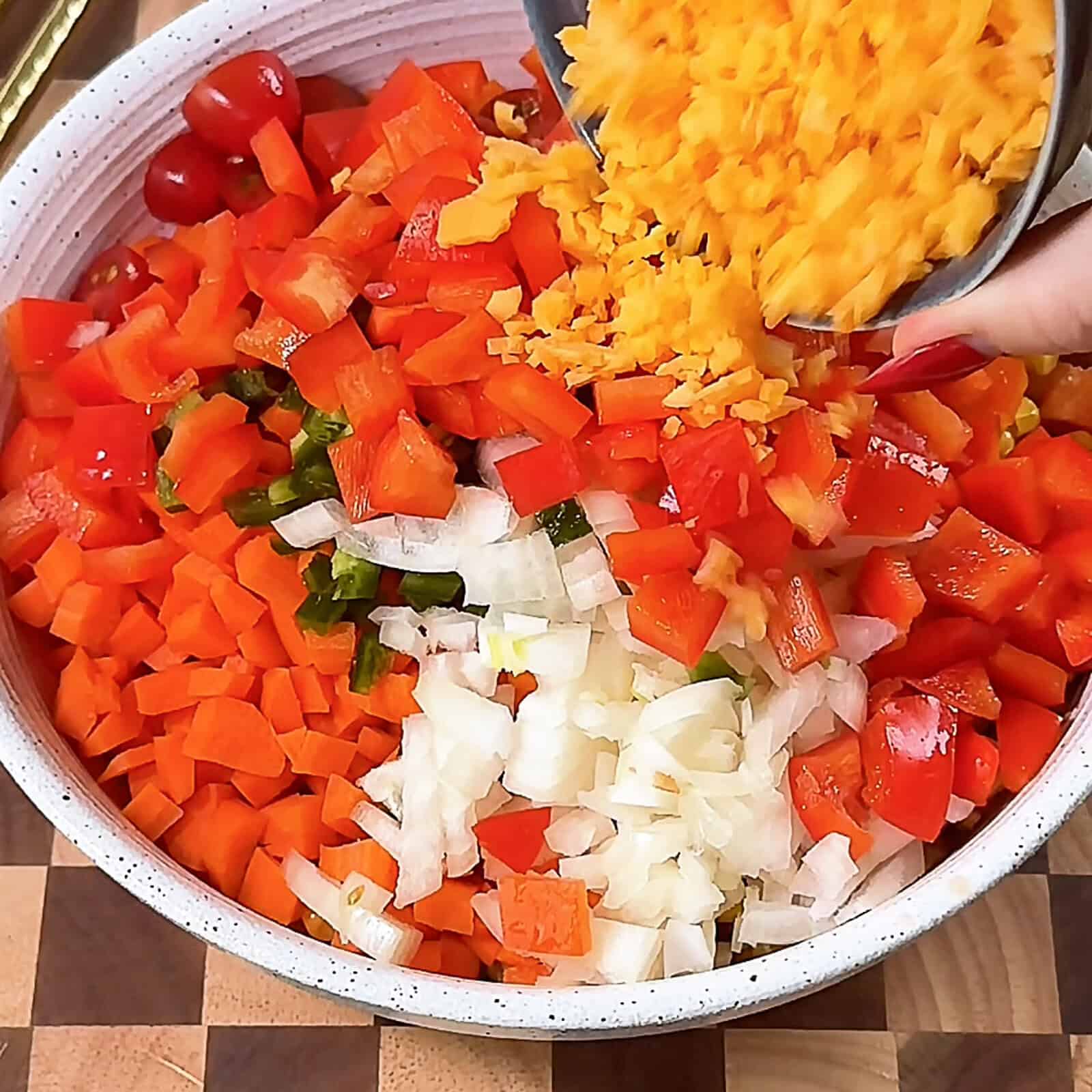 Combining diced vegetables and shredded cheese for Make-Ahead Corn Salsa Dip