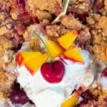 easy cherry peach crisp with oat crumble dessert topped with vanilla ice cream and fresh fruit