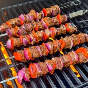 Barbecue steak kebabs with vegetables cooking on a gas grill