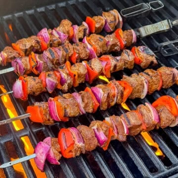 Barbecue steak kebabs with vegetables cooking on a gas grill