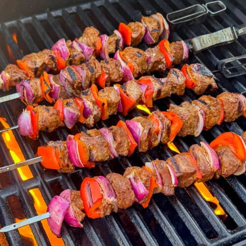 Barbecue steak kebabs with vegetables cooking on a gas grill