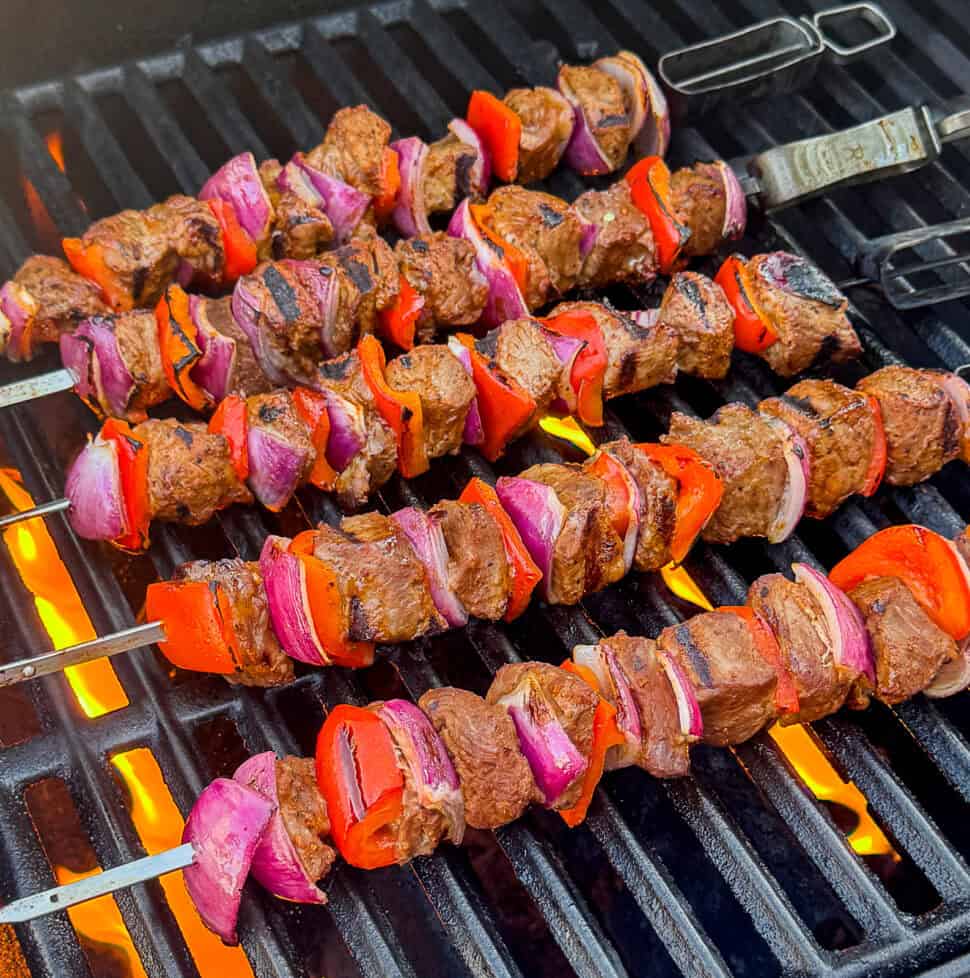 Barbecue steak kebabs with vegetables cooking on a gas grill